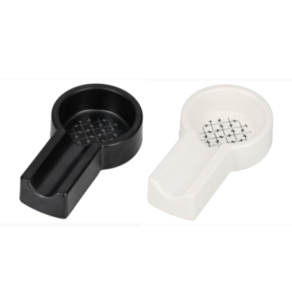 Two small plastic ashtraysshown on a plain white background: one black and one white, each with a circular opening and a small grid-like printed area in the center