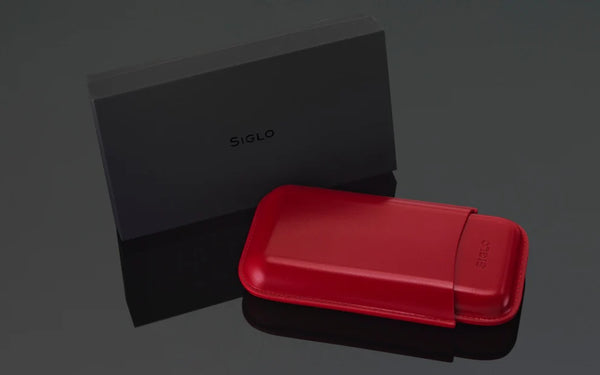 Red Siglo cigar case with black box featuring 'Siglo' brand on a dark background