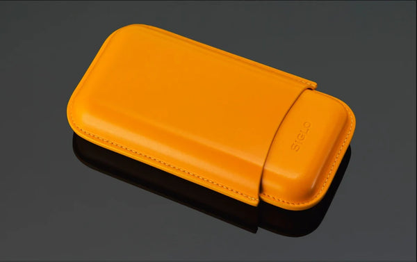 Orange Siglo leather case with a brand logo on a dark gray background